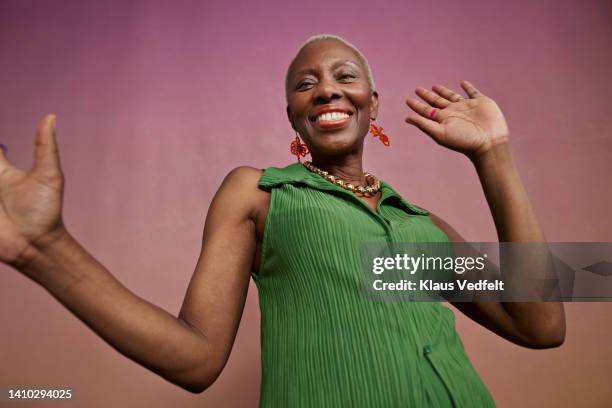 portrait of joyful senior woman dancing - woman sleeveless dress stock pictures, royalty-free photos & images