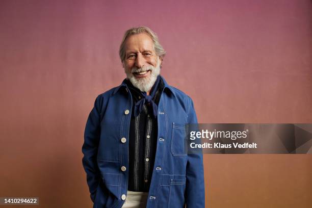 portrait of happy senior man in denim jacket - giacca blu foto e immagini stock