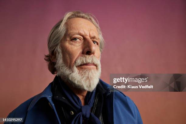 serious senior man with beard looking away - gezichtsuitdrukking stockfoto's en -beelden