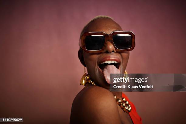 senior woman with eyeglasses sticking out tongue - tong uitsteken stockfoto's en -beelden