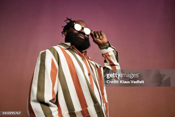 confident mature man wearing sunglasses - striped shirt stockfoto's en -beelden