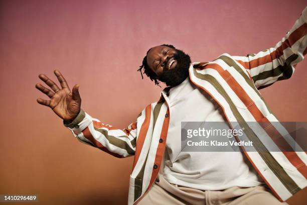 joyful man in striped shirt dancing in studio - only mature men fotografías e imágenes de stock