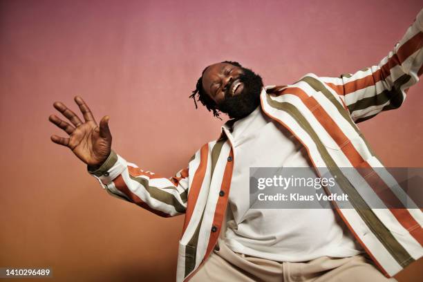 joyful man in striped shirt dancing in studio - endast medelålders män bildbanksfoton och bilder