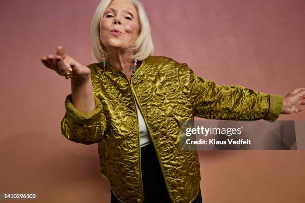 portrait of elderly woman blowing kiss - studio kiss stock-fotos und bilder