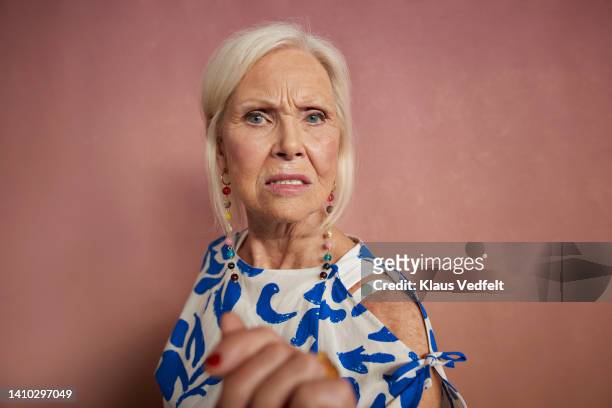 portrait of angry senior woman - cross stockfoto's en -beelden