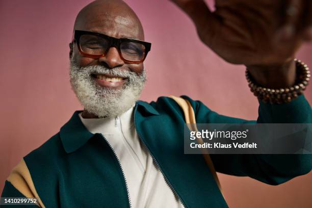 happy senior man wearing eyeglasses - groen jak stockfoto's en -beelden