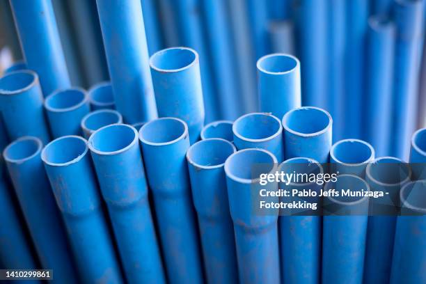 stack of pvc blue pipes - pvc fotografías e imágenes de stock