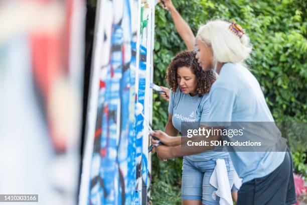 female volunteers work together - cleaning graffiti stock pictures, royalty-free photos & images