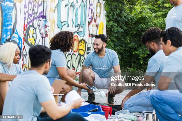 volunteers take a break together - community imagens e fotografias de stock