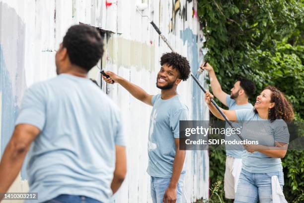 young adult male smiles at the camera - cleaning graffiti stock pictures, royalty-free photos & images