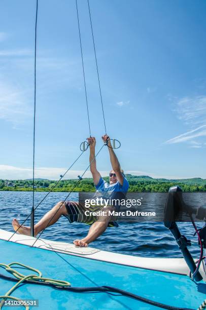 homem maduro segurando corda para empurrar quilha de catamarã - quilha - fotografias e filmes do acervo