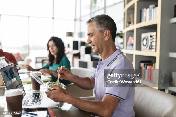 happy businessman eating salad at desk in office - colleague lunch stock pictures, royalty-free photos & images
