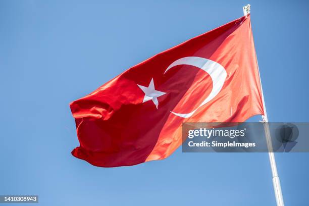 the turkish flag is blowing in the wind - bandera turca fotografías e imágenes de stock