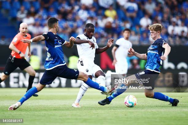 Christian Kinsombi of Sandhausen is challenged by Klaus Gjasula and Clemens Riedel of Darmstadt during the Second Bundesliga match between SV...