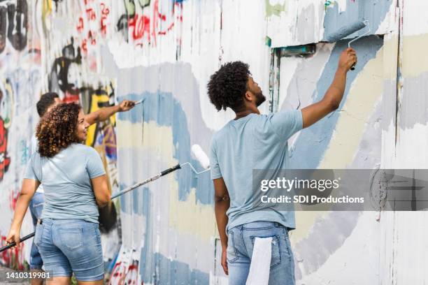 volunteers cover the graffiti with waves of paint - public park usa stock pictures, royalty-free photos & images