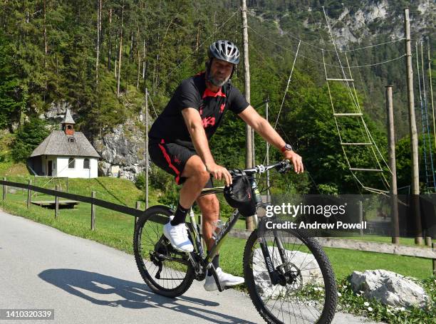 Jurgen Klopp manager of Liverpool arriving before a training session on a bicycle at the Liverpool pre-season training camp on July 22, 2022 in...