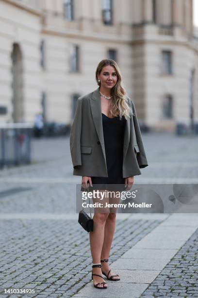 Helena Milchrahm is seen wearing Bruna The Label necklace, silver rings and earrings, a black midi dress, black high heels, a black mini Chanel...