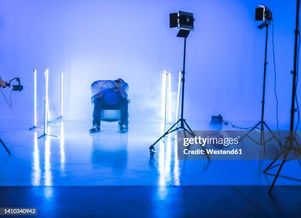 singer sitting on chair filming at studio - movie set stock pictures, royalty-free photos & images