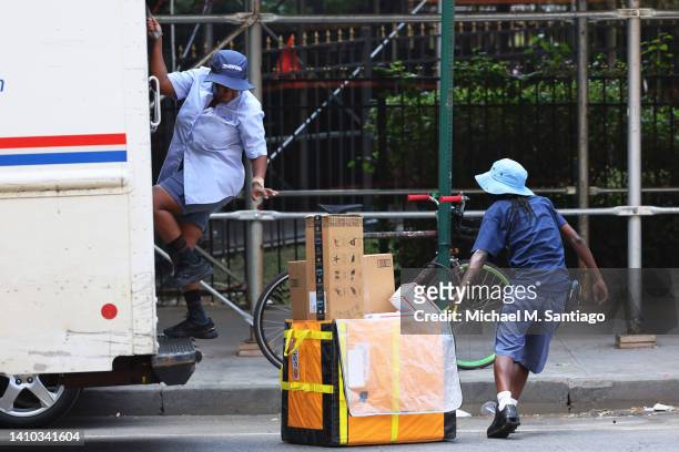 Mail delivery workers unload a truck on Flatbush Avenue on July 22, 2022 in the Flatbush neighborhood of the Brooklyn borough in New York City. A...