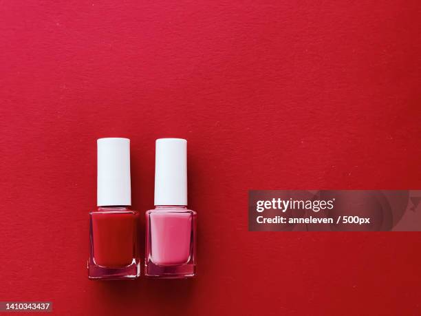 red and pink nail polish bottles on red background,manicure and - bottles glass top stock pictures, royalty-free photos & images