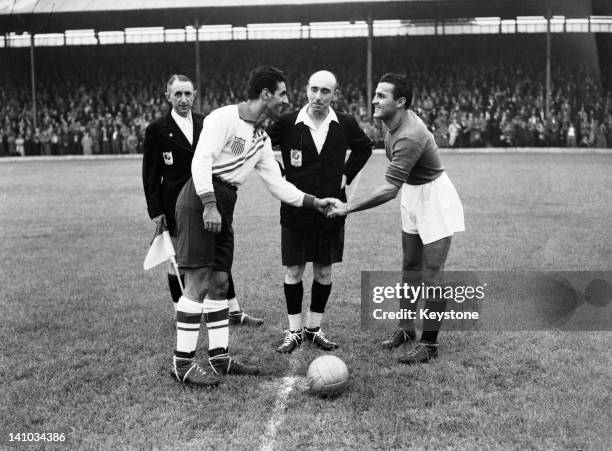 Football captains Maino Neri , of Italy and John Souza of the USA shake hands before a first round match at Griffin Park, Brentford during the London...