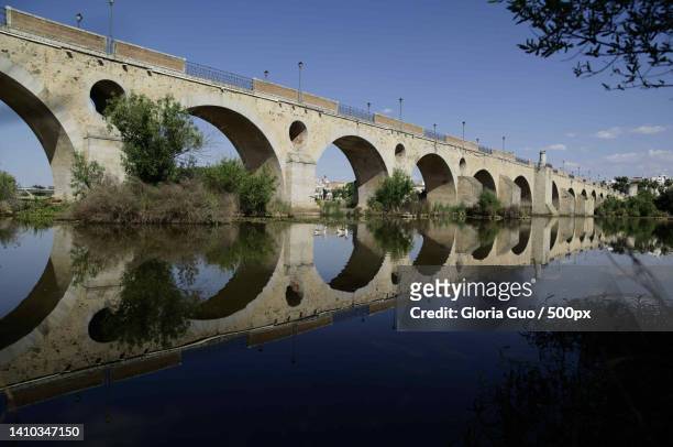 low angle view of arch bridge over river against sky,spain - aqueduct stockfoto's en -beelden