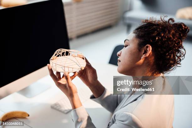 businesswoman examining architectural model at office - architekturmodell stock-fotos und bilder