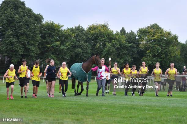 Baton bearer Lizzie Brunt carries the Queen's Baton with horse Pineau de Re during the Birmingham 2022 Queen's Baton Relay at a visit to Worcester...