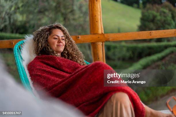 latin woman is on the balcony of a beautiful country hotel warming her hands with the campfire - hot latin nights stock pictures, royalty-free photos & images