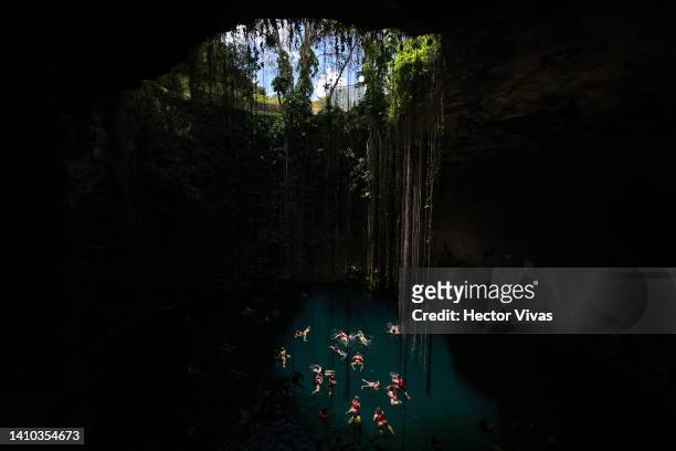 Tourists swim in the Ik-Kil cenote, one of the most visited due to its proximity to the Mayan ruins of Chichen Itza on July 16, 2022 in Piste,...