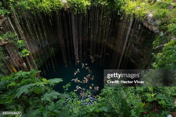 Tourists swim in the Ik-Kil cenote, one of the most visited due to its proximity to the Mayan ruins of Chichen Itza on July 16, 2022 in Piste,...