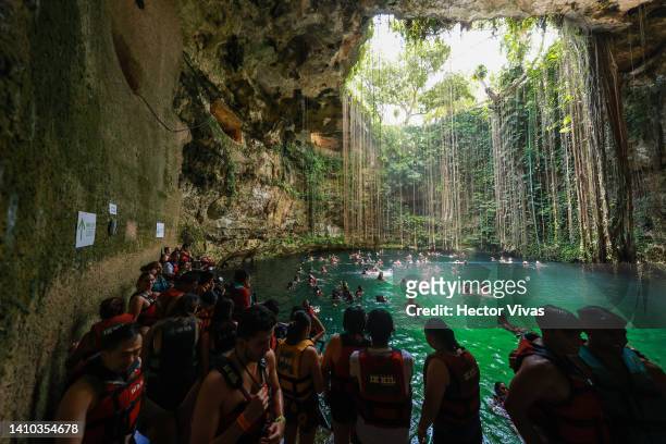Tourist make a line in the crowded stairs to dive into the Ik-Kil cenote, one of the most visited due to its proximity to the Mayan ruins of Chichen...