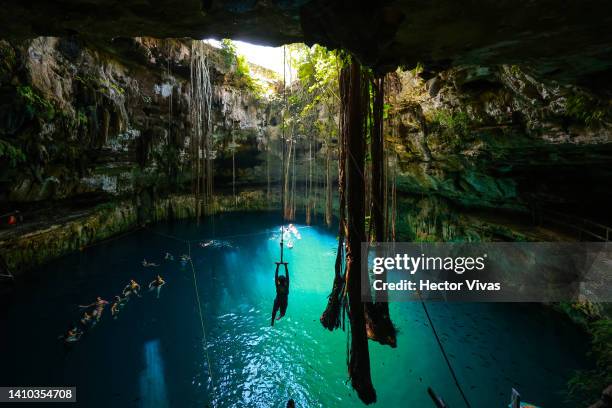 Tourist swings on a zip line to in the Oxman cenote on July 16, 2022 in Valladolid, Mexico. The Yucatan Peninsula has the world's largest underwater...