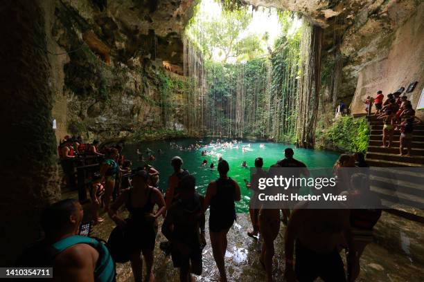 Tourist make a line in the crowded stairs to dive into the Ik-Kil cenote, one of the most visited due to its proximity to the Mayan ruins of Chichen...