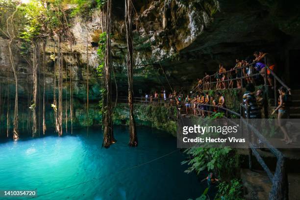 Group of tourists observe the Oxman cenote from a catwalk on July 16, 2022 in Valladolid, Mexico. The Yucatan Peninsula has the world's largest...