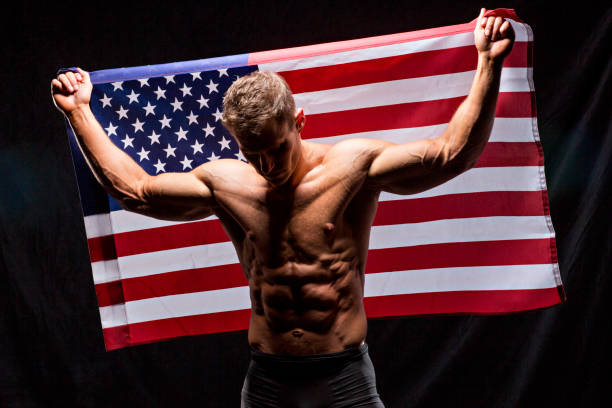 male with muscles, no fat and the american flag photographed in a studio. - republican bodybuilder stock pictures, royalty-free photos & images