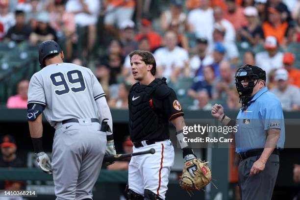 Aaron Judge of the New York Yankees talks with catcher Adley Rutschman of the Baltimore Orioles during the first inning at Oriole Park at Camden...