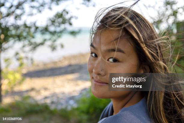 gorgeous chinese woman enjoys the wind blowing through her hair by the ocean in maine - streak bildbanksfoton och bilder