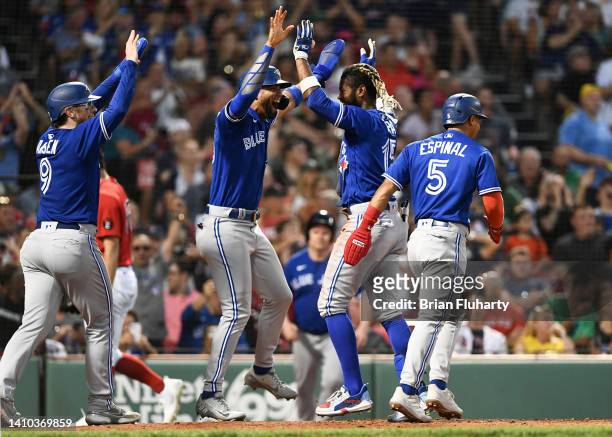 Raimel Tapia of the Toronto Blue Jays celebrates with Lourdes Gurriel Jr. #13 and Danny Jansen after hitting an inside the park grand slam against...