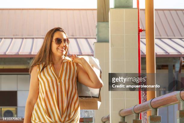 young latin pretty woman shopping in an outlet mall in miami beach, florida, usa - latin american and hispanic shopping bags stockfoto's en -beelden
