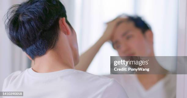 mann besorgt über haarausfall - asian hair stock-fotos und bilder