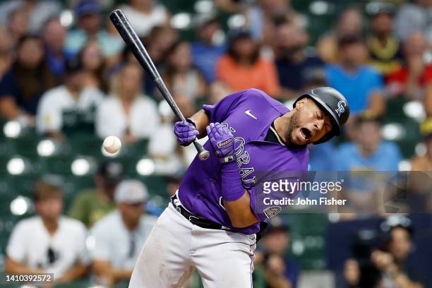 Elias Diaz of the Colorado Rockies is hit by a pitch in the eleventh inning against the Milwaukee Brewers at American Family Field on July 22, 2022...