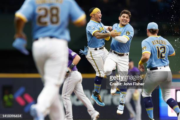 Luis Urias of the Milwaukee Brewers is congratulated by teammates after hitting a walk off single in the thirteenth inning against the Colorado...