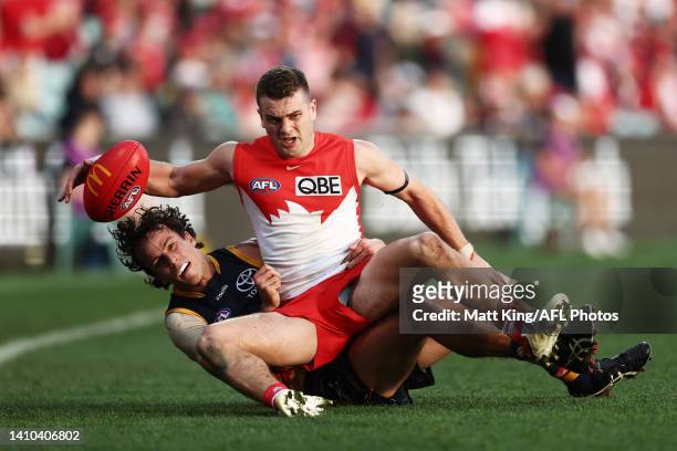 Tom Papley of the Swans is challenged by Will Hamill of the Crows during the round 19 AFL match between the Sydney Swans and the Adelaide Crows at...