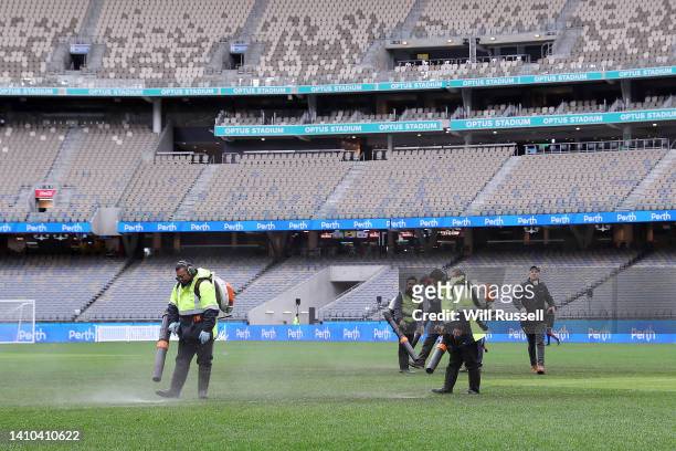 Ground staff attempt to dry the water logged pitch before the Pre-Season Friendly match between Manchester United and Aston Villa at Optus Stadium on...