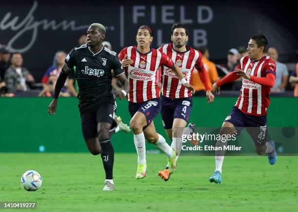 Paul Pogba of Juventus dribbles the ball up the field ahead of Angel Saldivar, Antonio Briseño and #Gilberto Garcia of Chivas during their preseason...