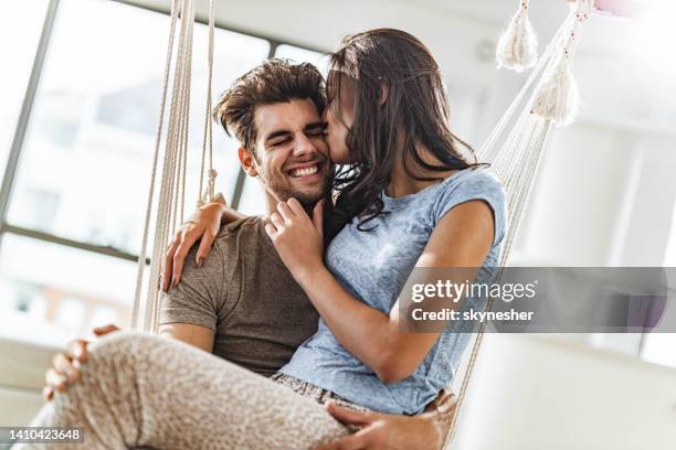 jovem casal amoroso curtindo em um balanço em casa. - cheek - fotografias e filmes do acervo