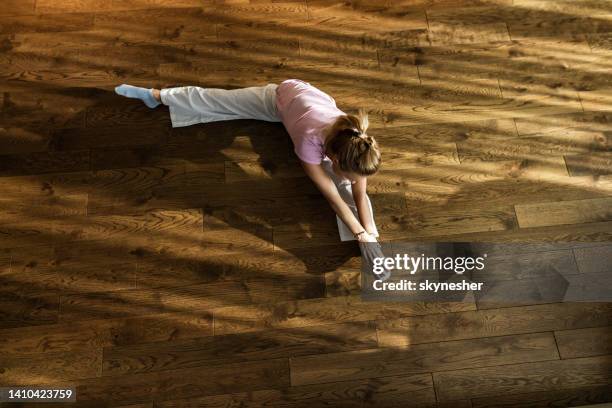 above view of a sportswoman stretching on parquet floor. - legs spread woman stock pictures, royalty-free photos & images