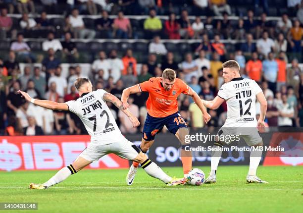 Patryk Szysz of Basaksehir FK fights for the ball with Eden Karzev and Yuval Sadeh of Maccabi Netanya during the UEFA Europa Conference League...