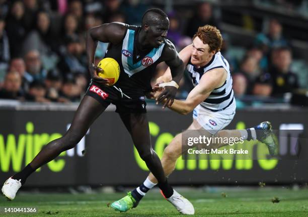 Aliir Aliir of Port Adelaide tackled by Gary Rohan of the Cats during the round 19 AFL match between the Port Adelaide Power and the Geelong Cats at...